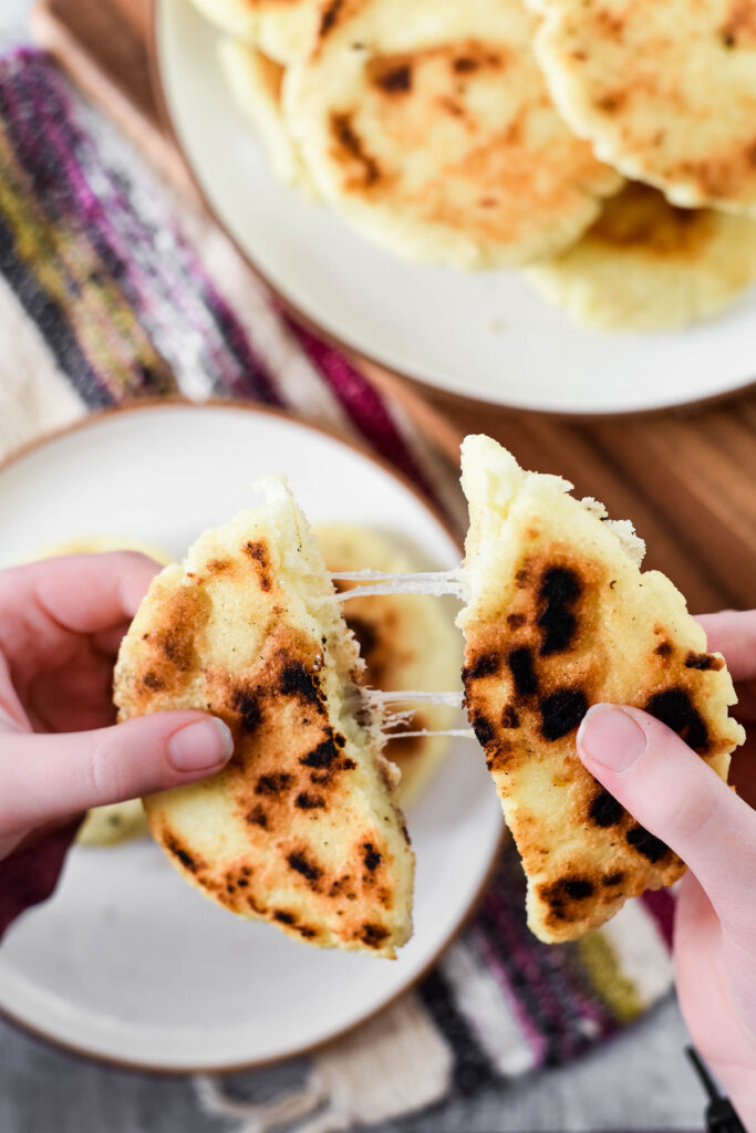 girl pulling cheese stuffed corn cakes