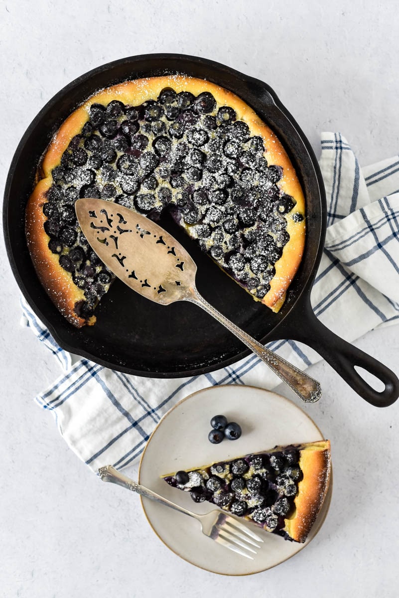 cast iron skillet with clafoutis and blueberries