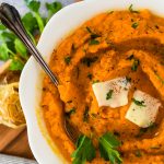 top down view mashed sweet potatoes with roasted garlic in white bowl