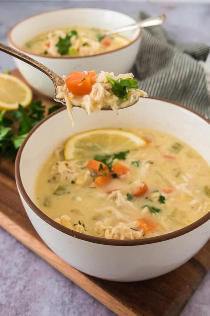 two bowls of soup with spoon hovering over one bowl filled with the soup