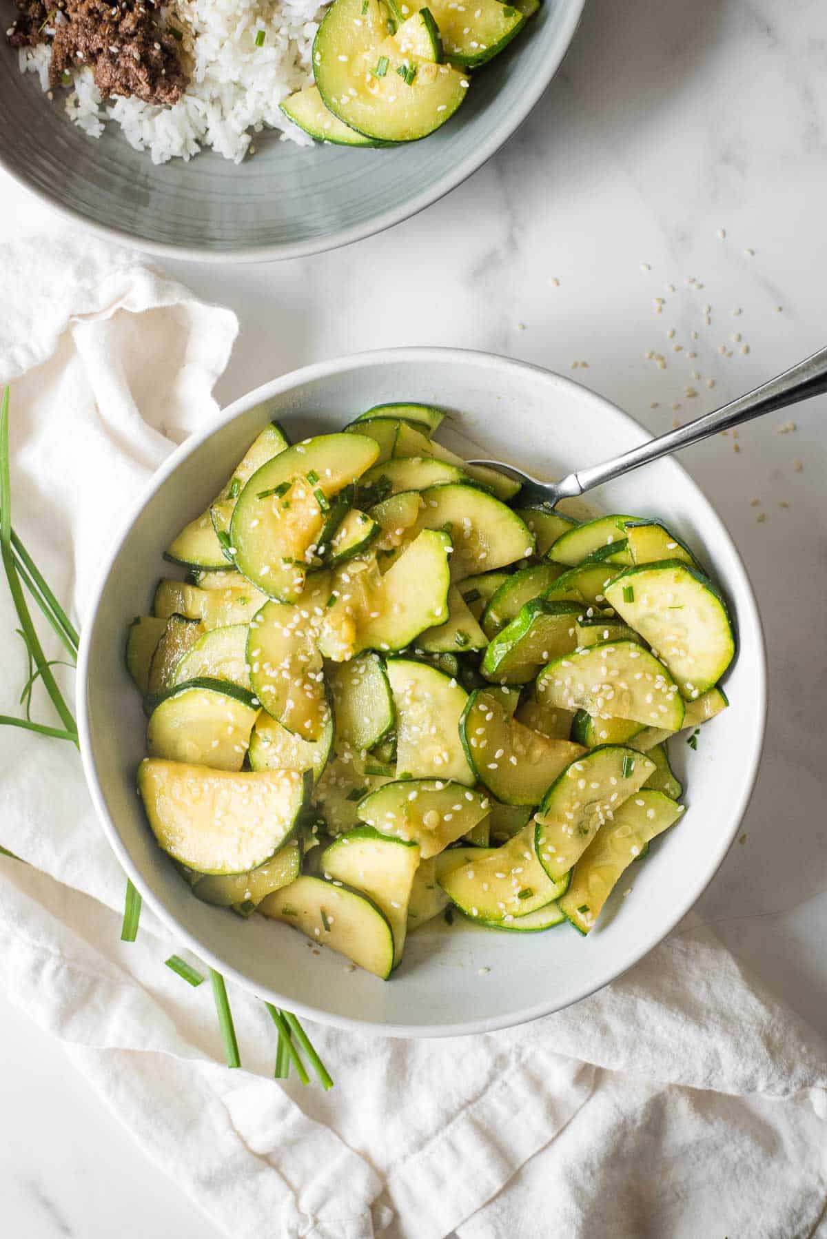 overhead view of zucchini cooked with green onions and sesame seeds
