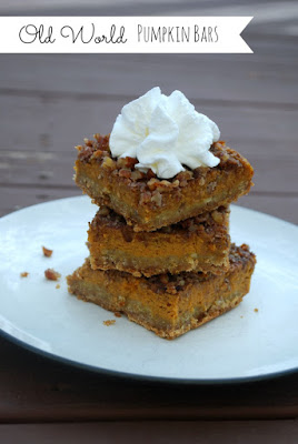 a stack of three pumpkin bars on a plate with whipped cream on the top